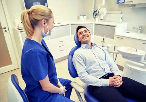 man smiling at a dental team member 